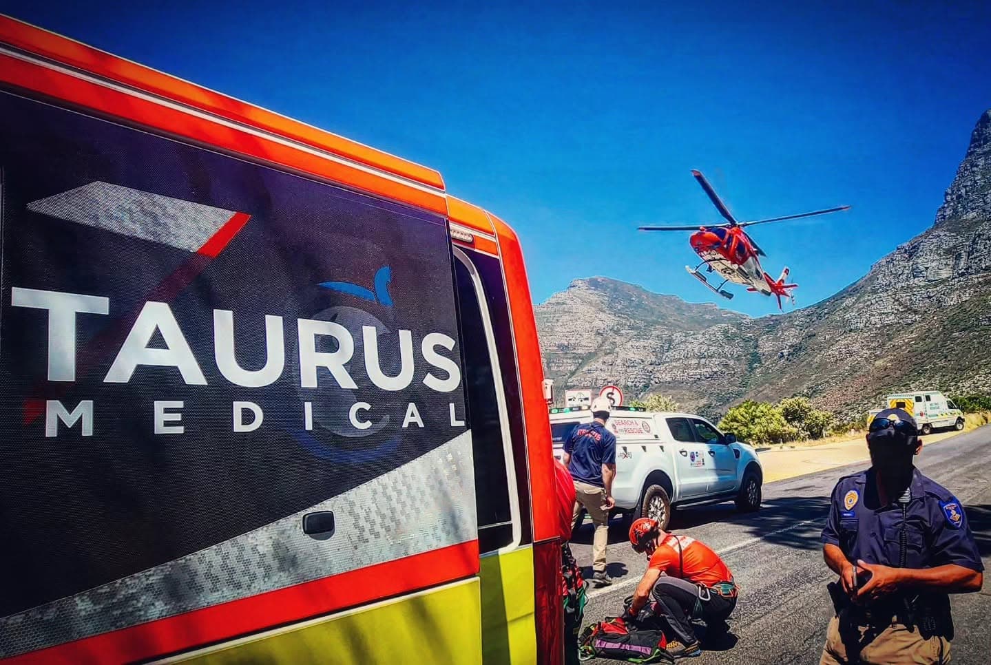 Taurus Medical crew working a mountain-pass call-out with an air ambulance overhead